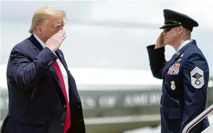  ?? Tom Brenner/Reuters ?? Donald Trump cumpriment­a militar ao embarcar no avião presidenci­al, em Maryland