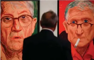  ?? Associated press ?? right Photo curator Julian Brooks looks at David Hockney’s self-portraits, iPad drawings printed on paper, June 21 at the Getty Center in Los Angeles.