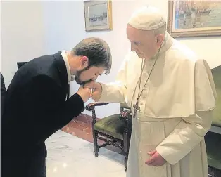  ??  ?? Tom Evans kisses Pope Francis’s hand at their meeting at the Vatican yesterday