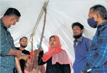  ??  ?? Noor Banu stands in her brother-in-law’s shelter as she speaks to her relatives and local Rohingyas about her missing son Mohammed Karim.