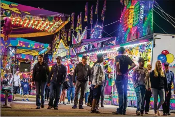  ?? Herald file photo by Ian Martens ?? Fairgoers make their way past the lights of the row of fair games during last year’s Whoop-Up Days. Exhibition Park has announced this year's festival will be cancelled due to the ongoing COVID-19 pandemic. @IMartensHe­rald