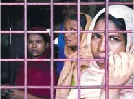  ?? AFPPIX ?? Refugee women look on as they sit in a school housing new arrivals from Myanmar in Kutupalong camp in the Bangaldesh­i district of Ukhia on Saturday.