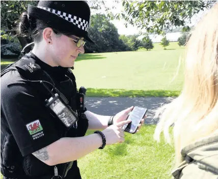  ??  ?? > An officer from North Wales Police uses a new custom-built Android smartphone app developed by Cardiff-based creative digital agency Sequence for the force