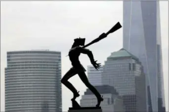  ?? AP PHOTO/JULIO CORTEZ ?? Buildings in Lower Manhattan provide a backdrop to a statue dedicated to the victims of the Katyn massacre of 1940, in Jersey City, N.J.