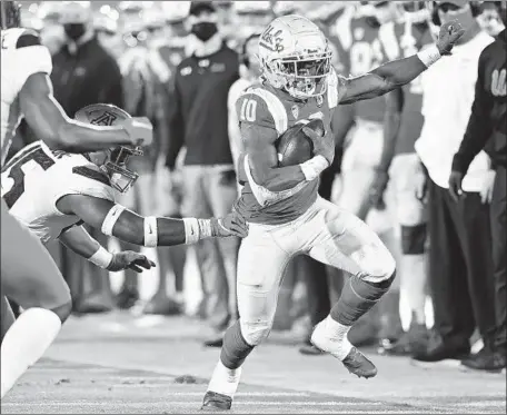  ?? BRUINS RUNNING BACK Jayne Kamin-Oncea Getty Images ?? Demetric Felton eludes Arizona’s McKenzie Barnes as he picks up a first down in the first half Saturday.