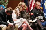  ??  ?? Jacki Dowling comforts her daughter Faith at the memorial service as she sits with her sons Foster, left, and Forrest.