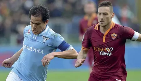  ??  ?? Sfida tra capitani Cristian Ledesma e Francesco Totti nel derby tra Lazio e Roma del 9 febbraio 2014: finì 0-0