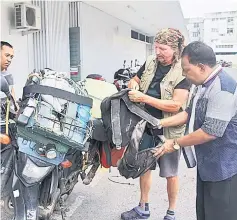  ??  ?? Hegel (second right) shows K. Manogaran (right) his motorcycle and his stuff.