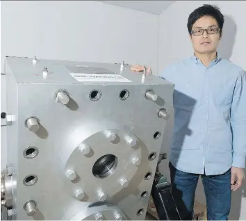  ?? MICHAEL BELL ?? Researcher Xiang Zhou stands beside a 3D model used to study fluid dynamics in Qingwang Yuan’s research lab at the University of Regina. Yuan has developed software that predicts the way oil will react with various fluids injected into wells during the...