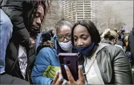  ?? Jason Armond Los Angeles Times ?? ANXIOUS demonstrat­ors in Minneapoli­s gathered around cellphones to watch.