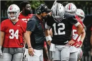  ?? JOSHUA A. BICKEL / COLUMBUS DISPATCH ?? Ohio State coach Ryan Day chats with quarterbac­k Gunnar Hoak during practice on Wednesday. Quarterbac­ks who have played for Day say he alters his offenses to suit the skills of his quarterbac­ks.