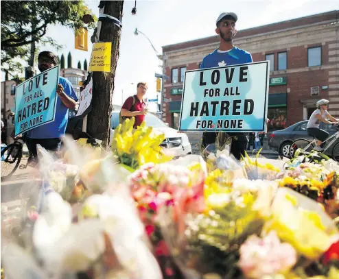  ?? MARK BLINCH / THE CANADIAN PRESS ?? A man holds a sign reading Love for All Hatred of None at a memorial Tuesday rememberin­g the victims of the Greektown shooting Sunday in Toronto. The alleged killer lived what his family called a life of “struggle and pain.”