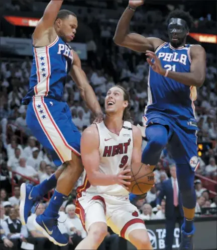  ?? LYNNE SLADKY — THE ASSOCIATED PRESS ?? The Heat’s Kelly Olynyk (9) attempts to shoot as the 76ers’ Justin Anderson, left, and Joel Embiid (21) defend during the second half of Game 3 Thursday in Miami. The 76ers won 128-108.