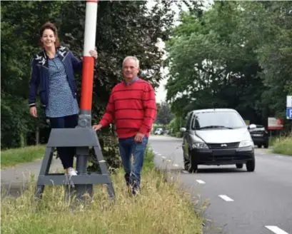  ?? FOTO GVB ?? Angeline Maas van Cultuurcra­an en Toon Duisters van de Cultuurraa­d Hamont-Achel bij de slagboom die straks een dag lang omlaag blijft.