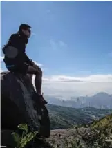  ??  ?? Trail runner Stone Tsang, 39, as he looks at the city from Hong Kong’s highest peak Tai Mo Shan.