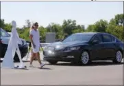  ?? THE ASSOCIATED PRESS ?? In this July 20, 2015 file photo, a pedestrian crosses in front of a vehicle as part of a demonstrat­ion at Mcity on its opening day on the University of Michigan campus in Ann Arbor, Mich.