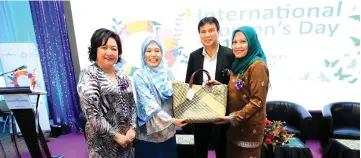  ??  ?? (From right) Datin Norasmah Kassim, who is the wife of Sharbini, presents a hand-woven bag crafted by Penan artisans from Murum, to Wan Wardatul Amani, witnessed by Aisah.