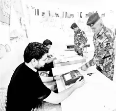  ??  ?? An Iraqi security member casts his vote at a polling station two days before polls open to the public in a parliament­ary election, in Najaf, Iraq. — Reuters photo