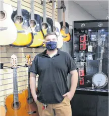 ?? OLIVIA MALLEY/THE NEWS ?? Store supervisor Ray Harris in front of Most Wanted Pawn’s guitar wall in New Glasgow.