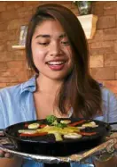  ??  ?? Marjolaine Custodio of Rekados Café and Restaurant with its Paella Negra