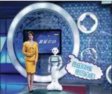  ?? PROVIDED TO CHINA DAILY ?? Chao Neng Xiao Bai, a 29-kg white robot, works with anchor Xiao Qu at Nanning TV Station.