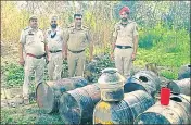  ?? HT PHOTO ?? Cops standing besides the seized stills near the Punjab-Himachal border in Bilaspur.