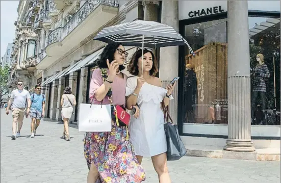  ?? MANÉ ESPINOSA ?? Dues turistes passejant pel passeig de Gràcia, el principal pol d’atracció per a les compres de luxe