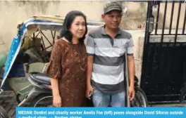  ??  ?? MEDAN: Dentist and charity worker Annita Foe (left) poses alongside David Sitorus outside a medical clinic. — Reuters photos