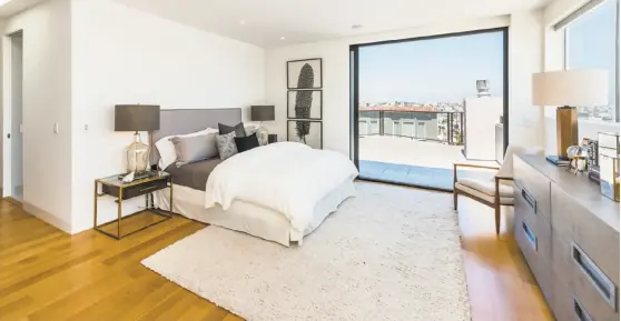  ??  ?? The master suite hosts a sliding glass wall opening to a patio with city views.