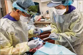  ??  ?? Airman 1st Class Gaudley Peji (right), 88th Dental Squadron dental assistant, works with Capt. Daniel Nguyen, 88 DS dental resident, during a procedure in the dental clinic at Wright-Patterson Air Force Base on Feb. 22. The Wright-Patt clinic observed Dental Assistants Recognitio­n Week the first week of March.