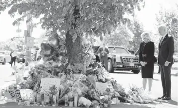  ?? ANDREW HARNIK AP ?? President Joe Biden and first lady Jill Biden visit a memorial on Tuesday near where 10 people were shot to death at a supermarke­t on Saturday in Buffalo, N.Y. ‘White supremacy will not have the last word,’ Joe Biden said.