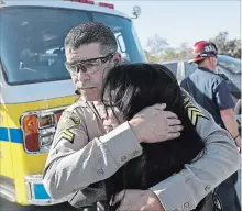  ?? MARCIO JOSE SANCHEZ THE ASSOCIATED PRESS ?? Los Angeles County Deputy Sheriff Armando Viera consoles an unidentifi­ed woman on a freeway overpass.