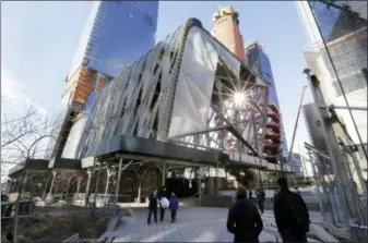  ?? RICHARD DREW — THE ASSOCIATED PRESS ?? People walk on the High Line Park that passes the Shed, center, in New York on March 6. The building, in Manhattan’s Hudson Yard’s developmen­t, is a new arts space consisting of a stationary building with a a shell constructe­d around it that can move...