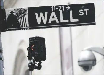  ?? AP PHOTO/MARY ALTAFFER ?? A Wall Street sign is seen next to surveillan­ce equipment outside the New York Stock Exchange, on Oct. 5 in New York.