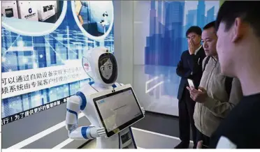  ??  ?? Face of future: Customers speaking with a robot at the automated branch of China Constructi­on Bank in Shanghai. — AP