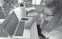  ?? NAM Y. HUH/AP ?? Kelly Mack works on her laptop last year to teach remotely from her early 1940s vintage camper/trailer in her backyard at home in Evanston, Ill.