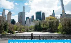  ?? —AFP ?? NEW YORK: A woman wearing a mask walks in the almost deserted Central Park in Manhattan in New York City.