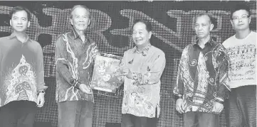  ??  ?? Tiong (second left) presents a souvenir to Wong. With them on the stage are, from left, Hii, Penguang and Andrew.