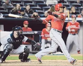  ?? Bill Kostroun Associated Press ?? hits a three-run home run as Yankees catcher Brian McCann looks on. Aybar’s shot was one of four homers for the Angels against New York.