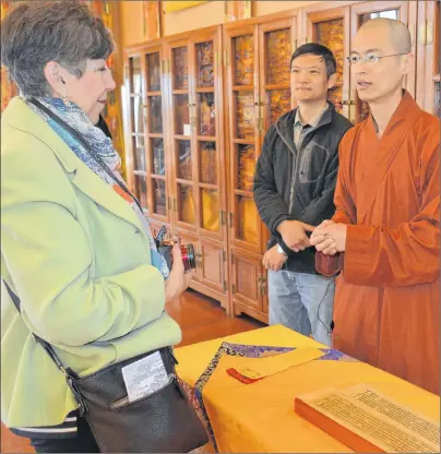  ?? KATIE SMITH/THE GUARDIAN ?? Venerable Victor shows Charlottet­own resident Betty Bordage some old Buddhist scriptures during an open house at the monastery in Little Sands on Sunday as Peter Li of Charlottet­own looks on. Victor said about 50 students are currently working on...