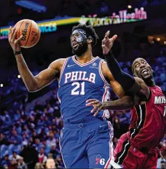  ?? MATT SLOCUM/ASSOCIATED PRESS ?? The 76ers’ Joel Embiid and Heat’s Bam Adebayo battle for the ball during Game 3 of their second-round playoff series Friday in Philadelph­ia. Wearing a hammer-tested mask, Embiid had 18 points and 11 rebounds after missing the first two games of the series.