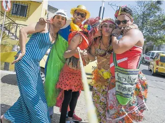  ?? CÉSAR BOLÍVAR ?? Un grupo de hombres del barrio Lucero, disfrazado­s de mujer, sujeta la cuerda de su peaje.