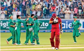  ??  ?? Pakistan's Imad Wasim (3rd-L) celebrates with teammates after bowling out West Indies' Andre Fletcher (C) during the first T20I match between Pakistan and West Indies at the Dubai Internatio­nal Cricket Stadium on September 23, 2016. -AFP