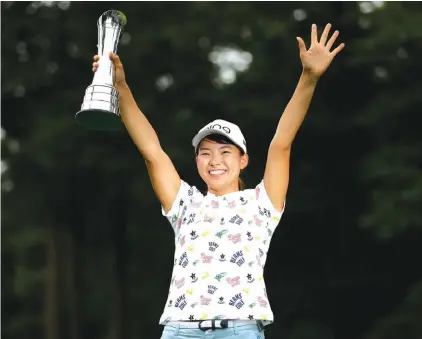  ??  ?? Japan’s Hinako Shibuno holds the trophy as she celebrates after winning the Women’s British Open golf championsh­ip