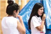  ?? ASHLEE REZIN GARCIA/SUN-TIMES ?? Karina (left) and Yazmin Camarena administer their own COVID-19 test swabs Wednesday at the pop-up testing site at 6424 S. Kenneth Ave. in West Lawn.