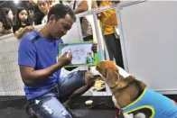  ?? HANUNG HAMBARA/JAWA POS ?? LUCU: Dexter dan pelatihnya, Winaryo, menunjukka­n kemampuann­ya untuk berhitung saat Surabaya Pet Expo di Pakuwon Trade Center kemarin.