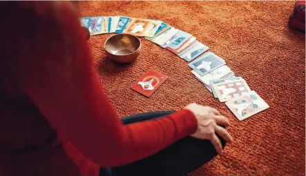  ?? Photos by Conscious Design / Unsplash / Creative Commons ?? A woman reads her fortune via tarot cards. Sales of tarot decks have increased 30 percent in recent years.