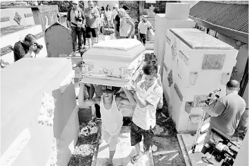  ??  ?? Relatives and loved ones of Leover Miranda, 39, a drug-related killing victim, carry his coffin during a funeral march at the north cemetery in metro Manila. — Reuters photo