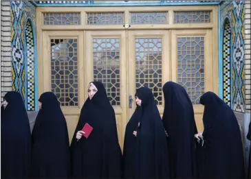  ?? The Associated Press ?? ELECTION: Female voters queue at a polling station for the presidenti­al and municipal council election Friday in the city of Qom, 78 miles (125 kilometers) south of the capital Tehran, Iran. Iranians began voting Friday in the country's first...