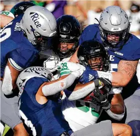  ?? Eric Christian Smith / Contributo­r ?? North Texas running back Ayo Adeyi (39) leans into some Rice defenders to score the game-winning touchdown in overtime Saturday at Rice Stadium.